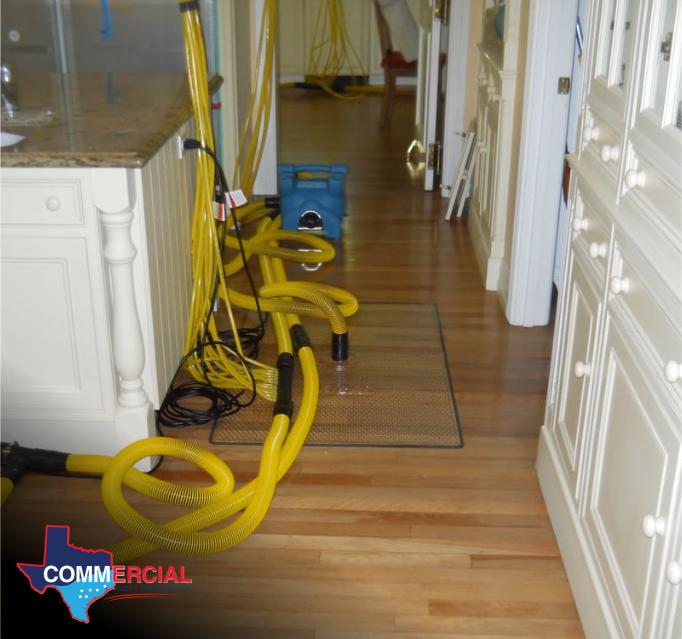 College Station water damage hallway with drying hoses