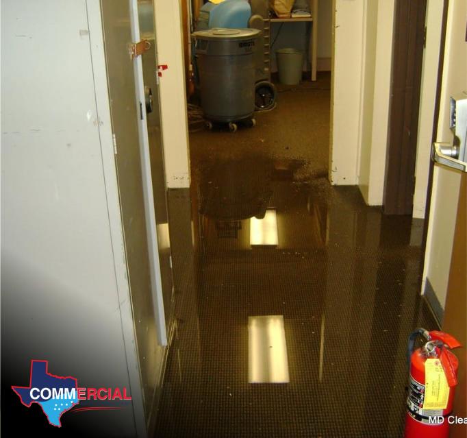 Commercial plumbing leak damage in a hallway